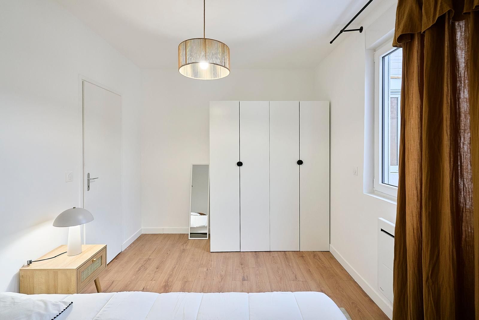 Chambre blanche avec armoire et suspension en corde