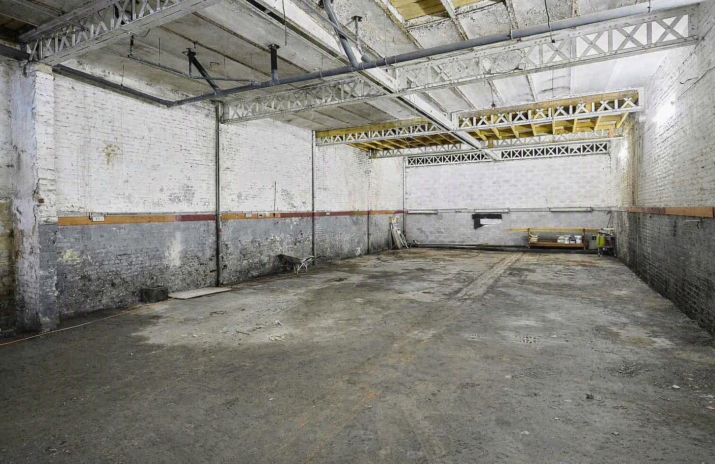 Hangar de 230 m² aux murs de brique blanchis et charpente métallique