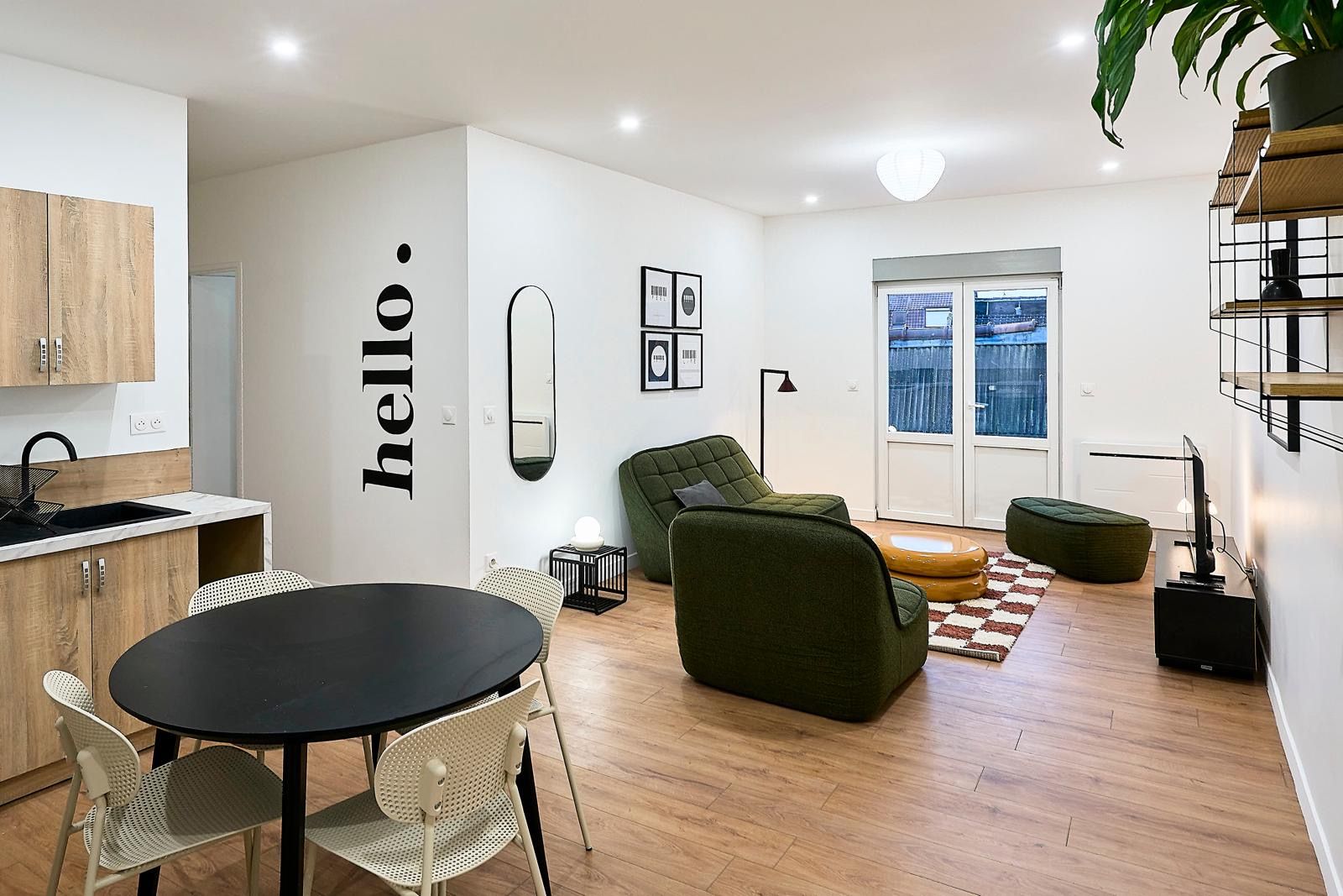 Séjour ouvert sur cuisine, fauteuils verts
