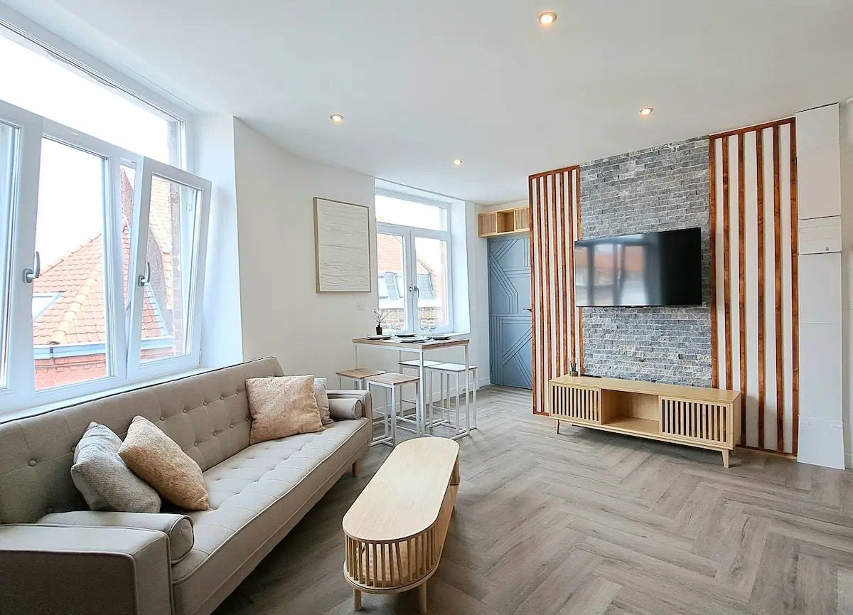 Séjour avec mur de brique et parquet en chevrons
